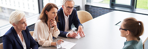 Woman during job interview and three elegant members of management